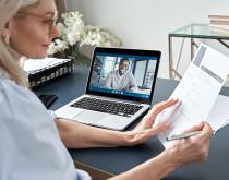 Woman virtually interviewing young man via laptop