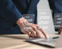 Businesswoman checking off list on laptop