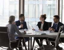 Diverse employees talking around a table