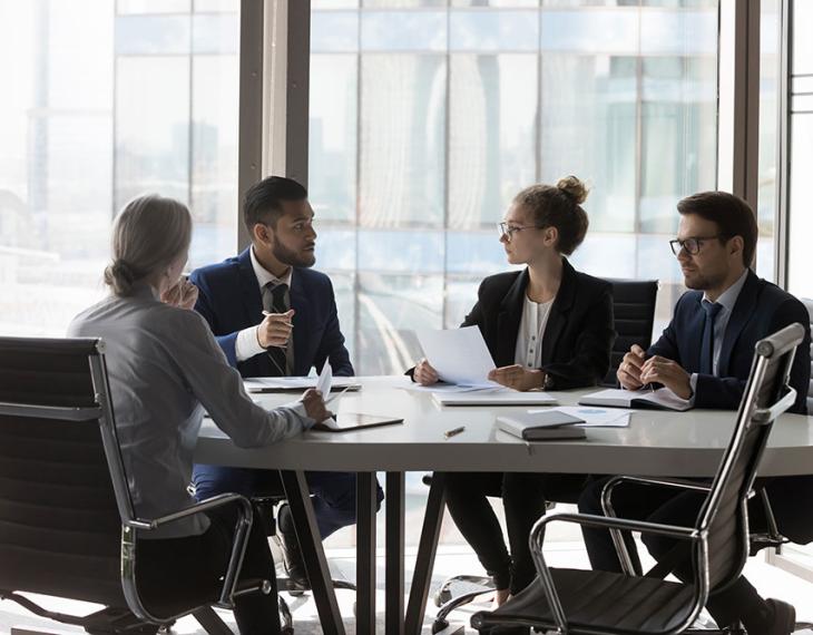 Diverse employees talking around a table